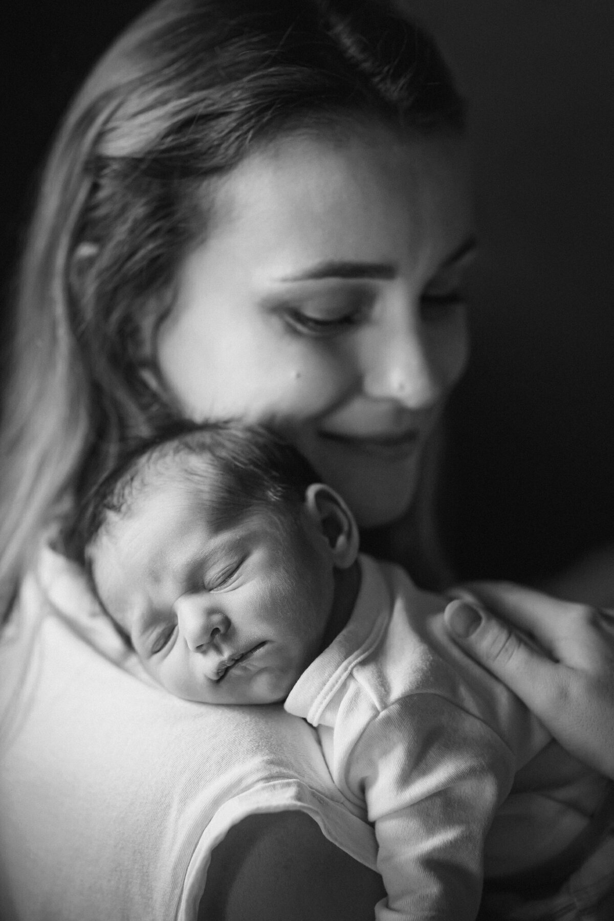 Lifestylowa sesja noworodkowa w domu - rodzina ubrana w jeansy i białe koszulki, a w roli głównej nowonarodzona dziewczynka