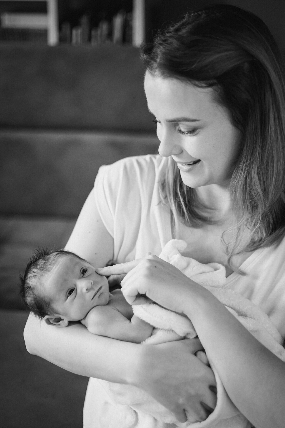 Lifestylowa sesja noworodkowa w domu - rodzina ubrana w jeansy i białe koszulki, a w roli głównej nowonarodzona dziewczynka