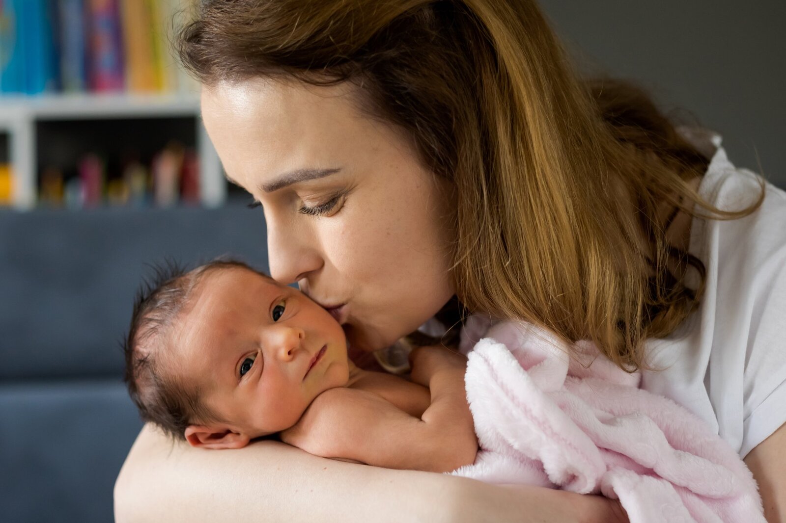 Lifestylowa sesja noworodkowa w domu - rodzina ubrana w jeansy i białe koszulki, a w roli głównej nowonarodzona dziewczynka