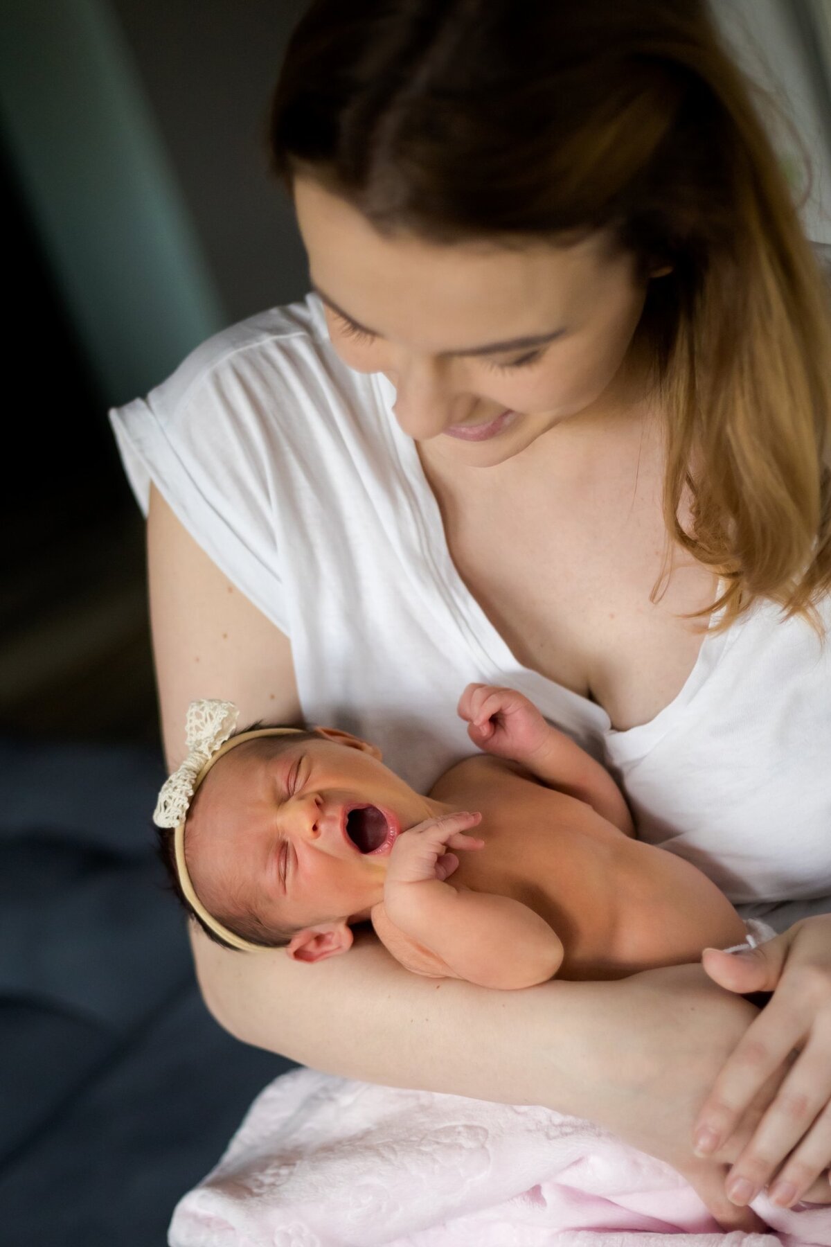 Lifestylowa sesja noworodkowa w domu - rodzina ubrana w jeansy i białe koszulki, a w roli głównej nowonarodzona dziewczynka