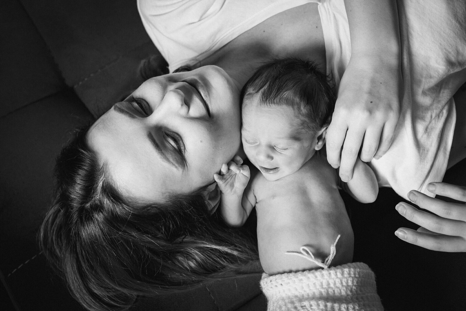 Lifestylowa sesja noworodkowa w domu - rodzina ubrana w jeansy i białe koszulki, a w roli głównej nowonarodzona dziewczynka