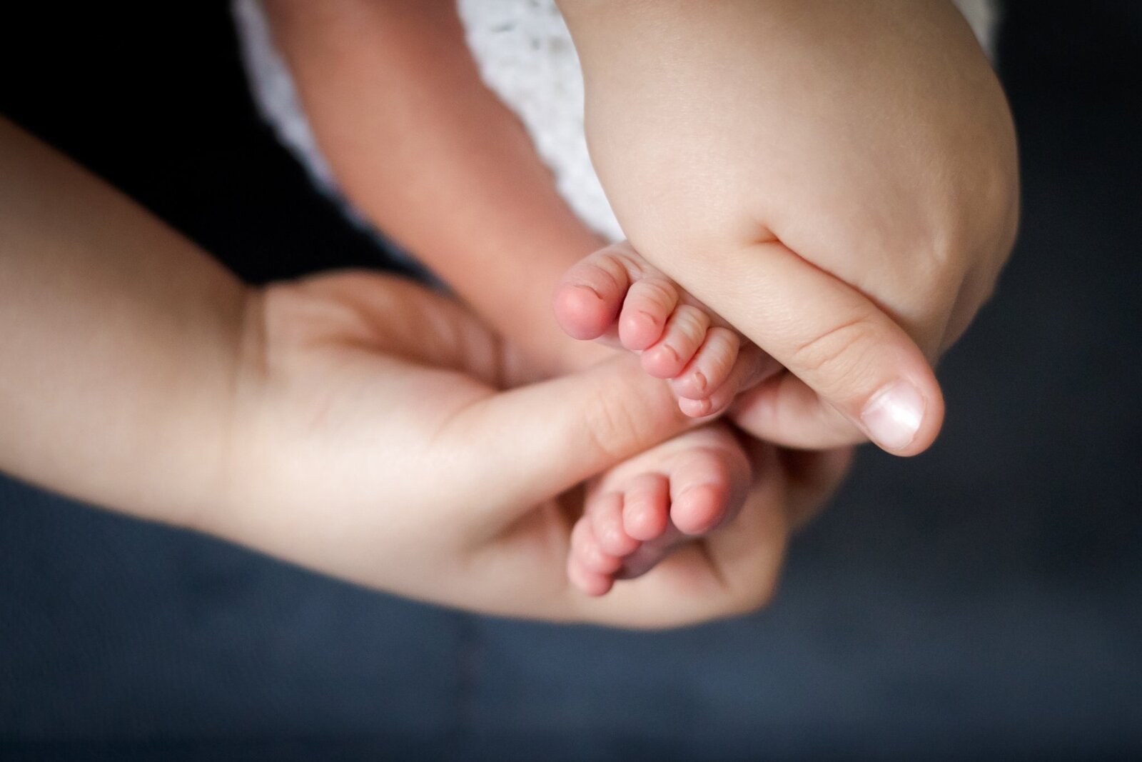 Lifestylowa sesja noworodkowa w domu - rodzina ubrana w jeansy i białe koszulki, a w roli głównej nowonarodzona dziewczynka